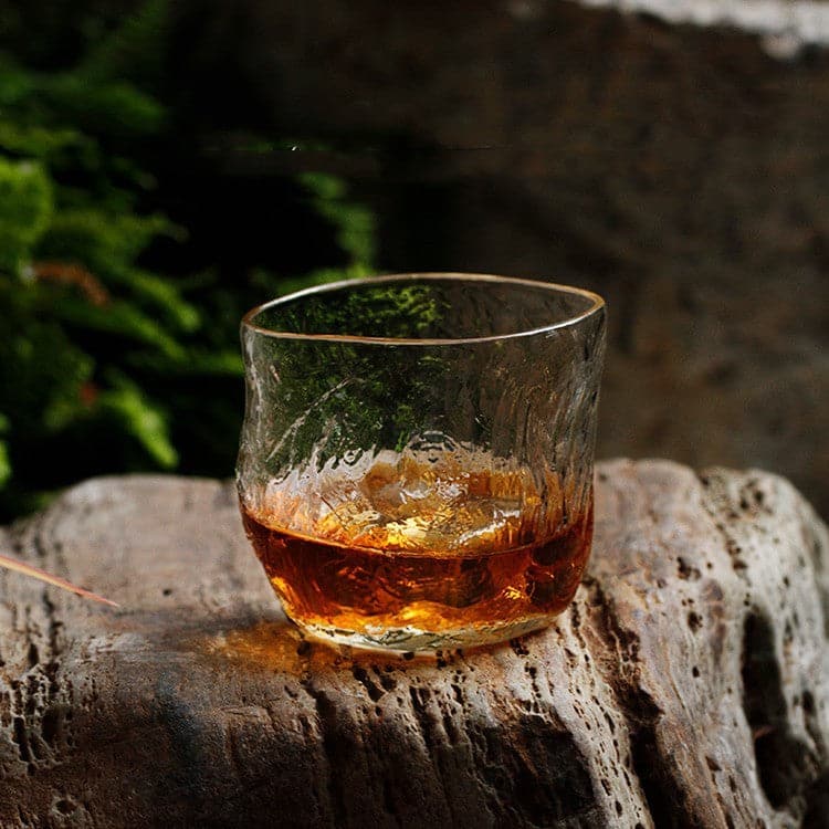 Japanese Style Whiskey Glass with heat-resistant glass, filled with whiskey, placed on a stone surface.